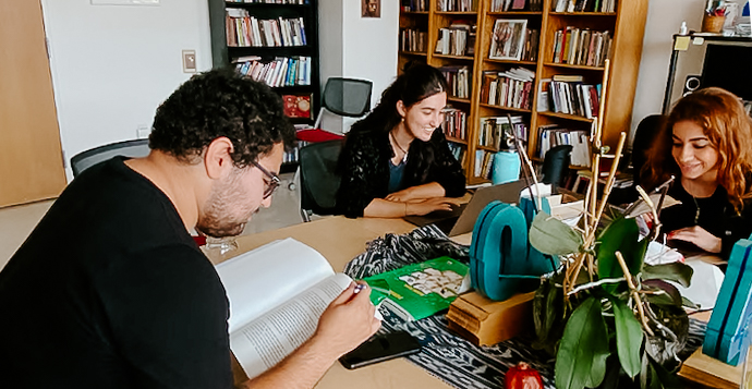 Three students study at a table