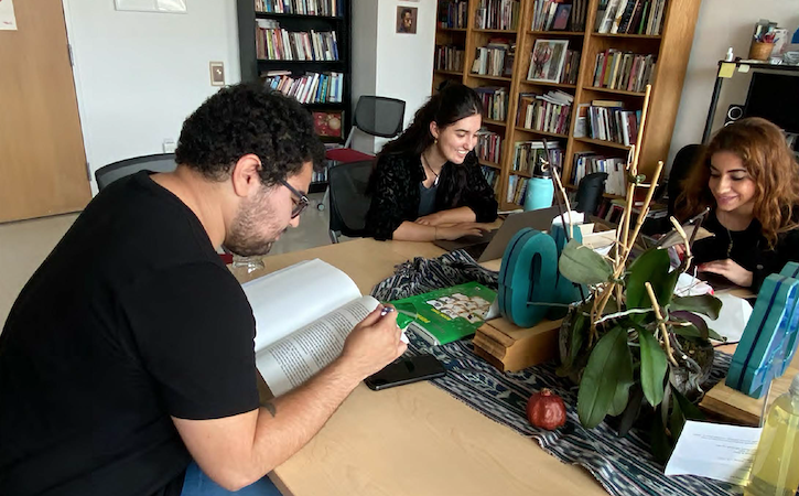 Three students study at a table